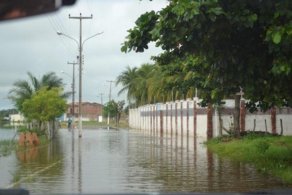 Com fortes chuvas água do açude transborda e invade ruas