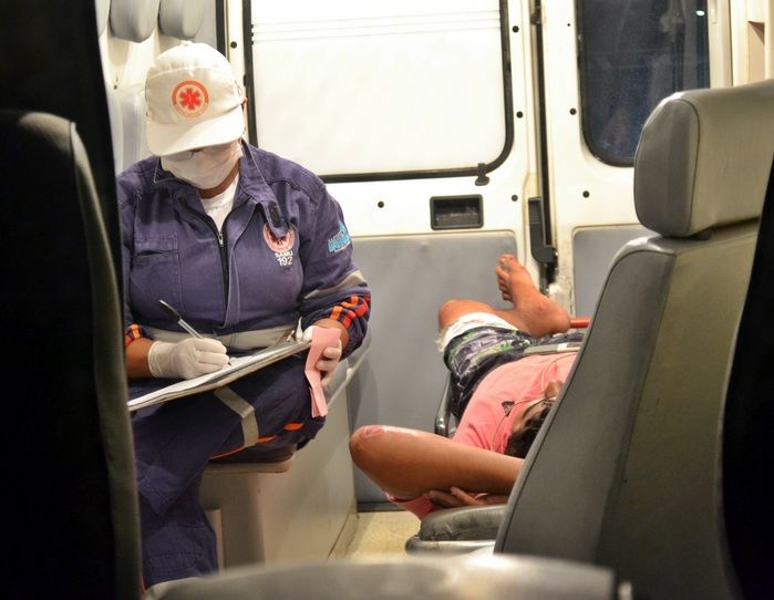 Motociclista sendo medicado dentro da ambulância. Ele sofreu apenas escoriações. (Foto: Kairo Amaral)
