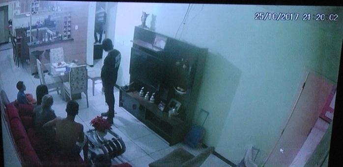 Um deles vigiava a família na sala da residência.  (Crédito: Reprodução)