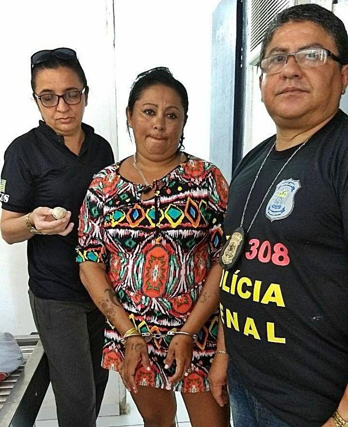 Mulher presa ao lado dos agentes que realizaram o flagrante.  (Crédito: Divulgação )